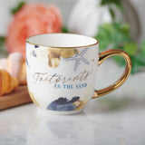 Footprints In The Sand Christian Ceramic Mug on a white table